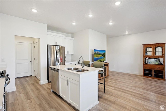 3270 N 3325 W Unit 386B, Plain City, UT 84404 - kitchen with appliances with stainless steel finishes, light wood-style floors, white cabinets, a center island with sink, and light countertops