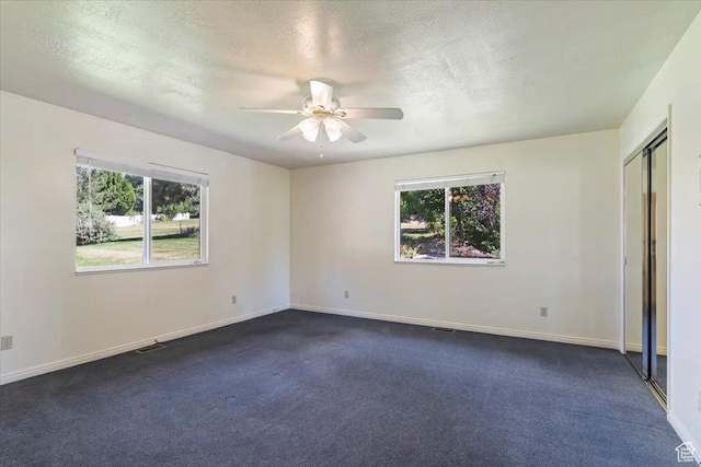 484 E 3450 N, North Ogden, UT 84414 - unfurnished bedroom with multiple windows, a textured ceiling, dark carpet, and a ceiling fan