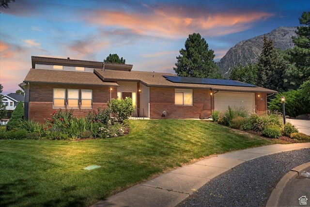 484 E 3450 N, North Ogden, UT 84414 - view of front of home with brick siding, roof mounted solar panels, a yard, and a garage