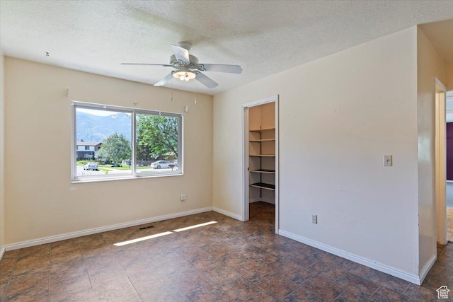 484 E 3450 N, North Ogden, UT 84414 - unfurnished bedroom with a spacious closet, a textured ceiling, and a ceiling fan