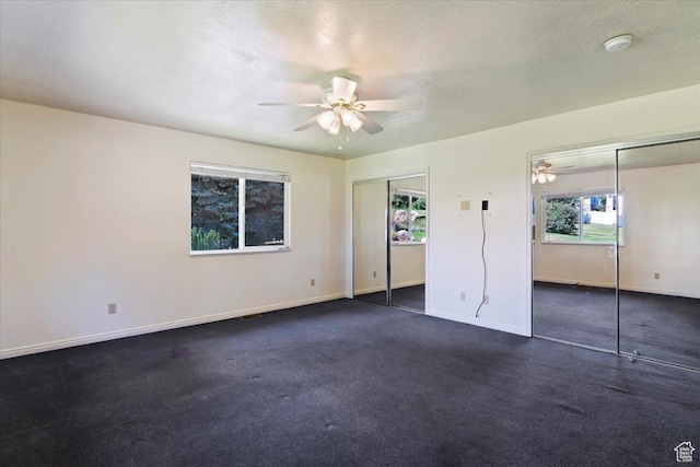 484 E 3450 N, North Ogden, UT 84414 - unfurnished bedroom with two closets, dark carpet, ceiling fan, and a textured ceiling