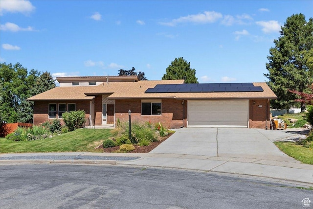 484 E 3450 N, North Ogden, UT 84414 - view of front of home featuring concrete driveway, a garage, roof mounted solar panels, brick siding, and a front yard