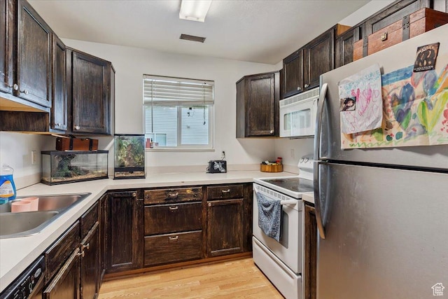 2421 N 400 E Unit C4, North Ogden, UT 84414 - kitchen featuring white appliances, light wood-style floors, dark brown cabinetry, and light countertops