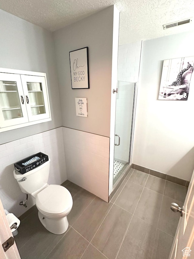 4086 W Wind River Dr, West Jordan, UT 84088 - full bath with a shower stall, a textured ceiling, tile walls, a wainscoted wall, and tile patterned floors