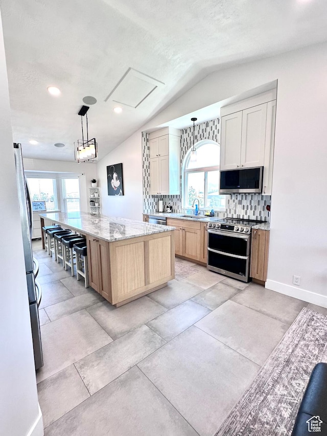 4086 W Wind River Dr, West Jordan, UT 84088 - kitchen featuring appliances with stainless steel finishes, lofted ceiling, plenty of natural light, backsplash, and light stone counters