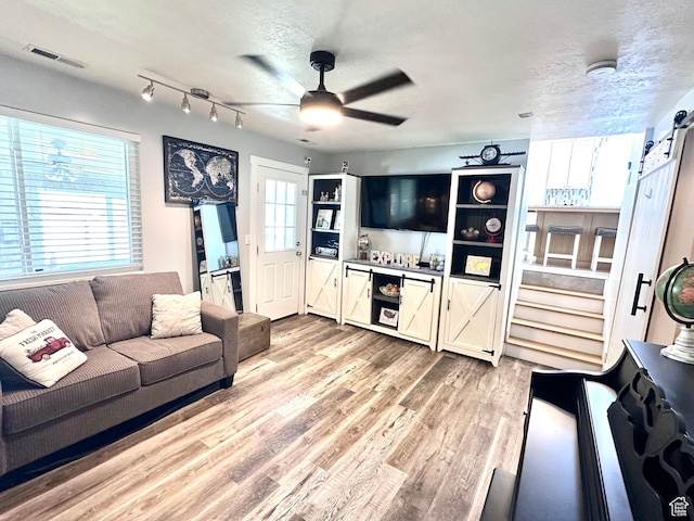 4086 W Wind River Dr, West Jordan, UT 84088 - living room with wood finished floors, a ceiling fan, and a barn door