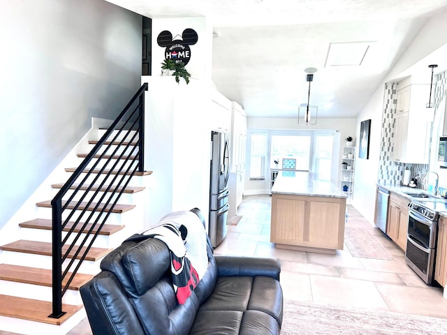 4086 W Wind River Dr, West Jordan, UT 84088 - kitchen with appliances with stainless steel finishes, a center island, vaulted ceiling, pendant lighting, and decorative backsplash