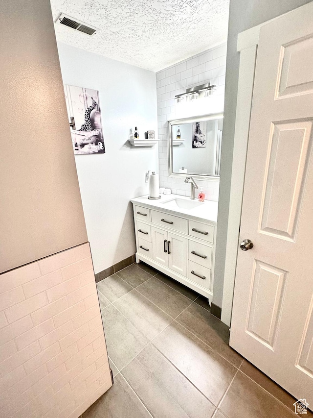 4086 W Wind River Dr, West Jordan, UT 84088 - bathroom with vanity, a textured ceiling, backsplash, and tile patterned floors