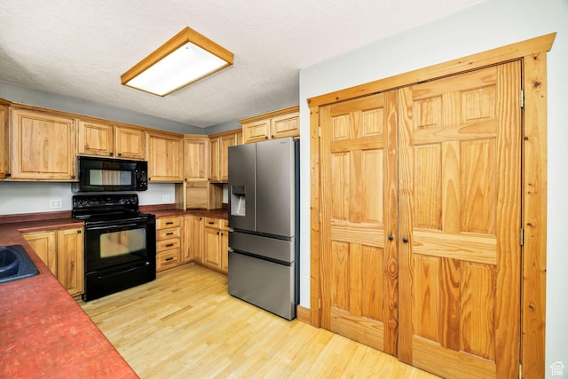 9115 W 25800 N, Portage, UT 84331 - kitchen featuring black appliances, dark countertops, light wood-type flooring, and a textured ceiling