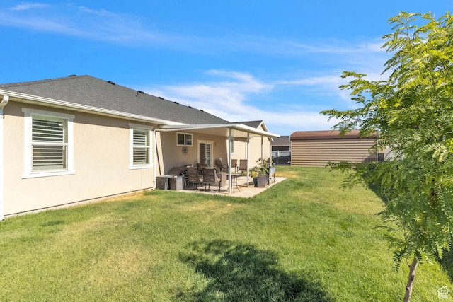1188 N 100 E, Nephi, UT 84648 - rear view of house with a patio, a lawn, stucco siding, and a shingled roof