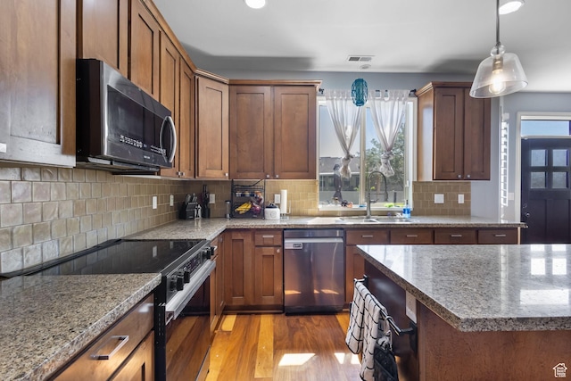 4467 W 5850 S, Hooper, UT 84315 - kitchen featuring black appliances, light wood finished floors, backsplash, pendant lighting, and light stone countertops