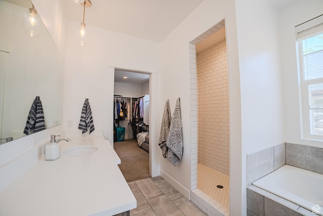 3698 E Butterfield Rd, Eagle Mountain, UT 84005 - bathroom featuring a garden tub, vanity, tiled shower, tile patterned floors, and a walk in closet