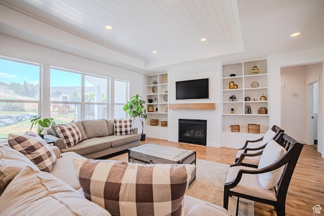 3698 E Butterfield Rd, Eagle Mountain, UT 84005 - living room featuring light wood-style floors, a raised ceiling, recessed lighting, built in features, and a large fireplace
