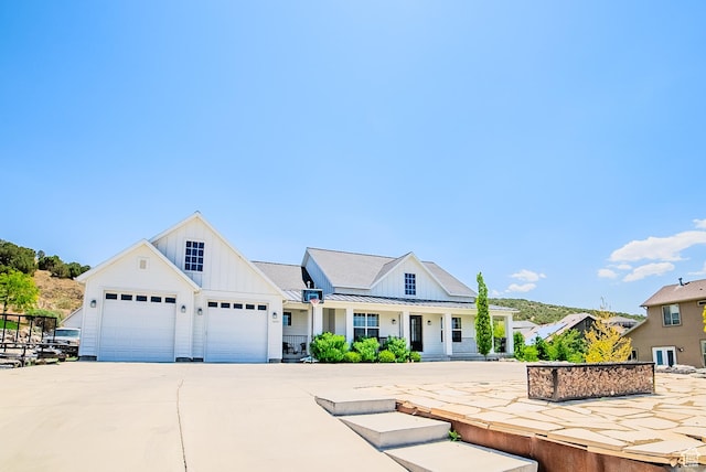3698 E Butterfield Rd, Eagle Mountain, UT 84005 - modern farmhouse style home with board and batten siding, concrete driveway, a standing seam roof, and covered porch