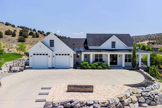 3698 E Butterfield Rd, Eagle Mountain, UT 84005 - modern farmhouse style home with board and batten siding, a standing seam roof, driveway, covered porch, and a garage
