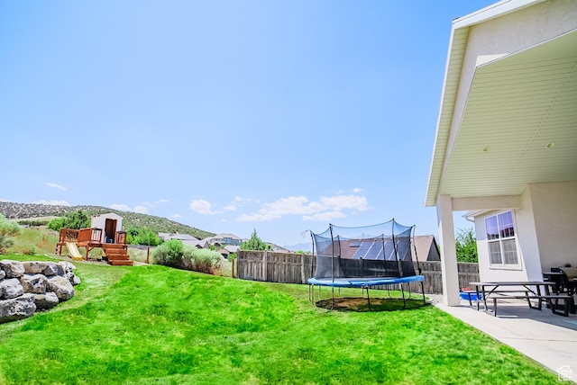 3698 E Butterfield Rd, Eagle Mountain, UT 84005 - fenced backyard with a trampoline, a playground, and a patio