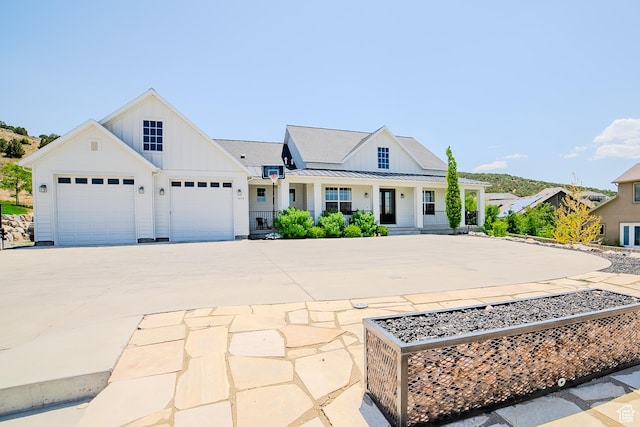 3698 E Butterfield Rd, Eagle Mountain, UT 84005 - modern farmhouse style home with board and batten siding, driveway, a porch, a standing seam roof, and a garage