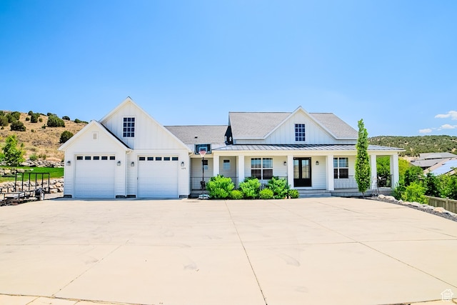 3698 E Butterfield Rd, Eagle Mountain, UT 84005 - modern farmhouse style home featuring board and batten siding, driveway, a porch, and a standing seam roof