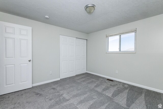 3320 N Plain City Rd W, Plain City, UT 84404 - unfurnished bedroom with carpet flooring, a closet, and a textured ceiling