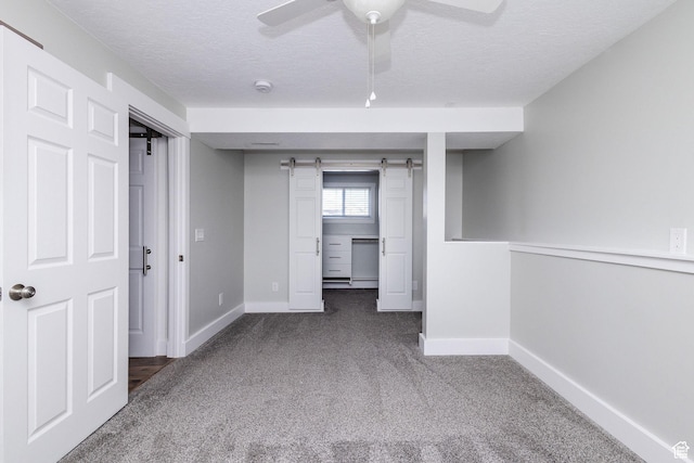 3320 N Plain City Rd W, Plain City, UT 84404 - carpeted spare room featuring a barn door, a textured ceiling, and a ceiling fan