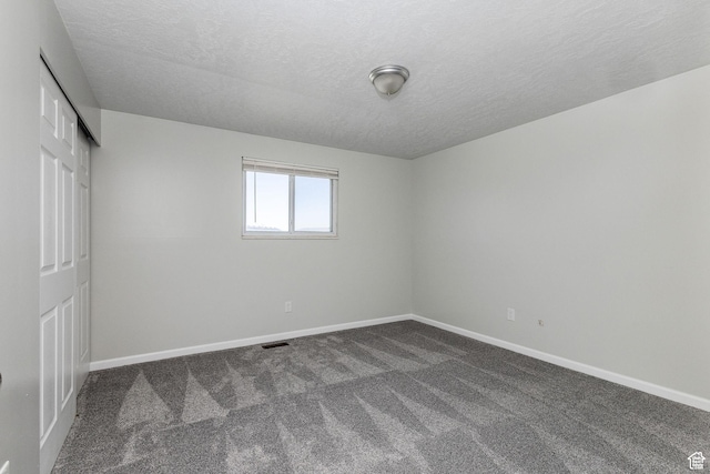 3320 N Plain City Rd W, Plain City, UT 84404 - unfurnished bedroom with dark carpet, a textured ceiling, and a closet