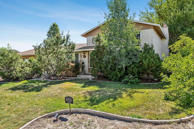 6924 S 2160 W, West Jordan, UT 84084 - view of property hidden behind natural elements featuring a front lawn and a chimney