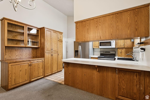 6924 S 2160 W, West Jordan, UT 84084 - kitchen with stainless steel appliances, a peninsula, light countertops, brown cabinets, and light colored carpet