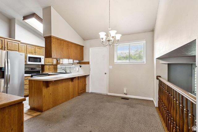 6924 S 2160 W, West Jordan, UT 84084 - kitchen with appliances with stainless steel finishes, brown cabinets, a chandelier, vaulted ceiling, and a peninsula