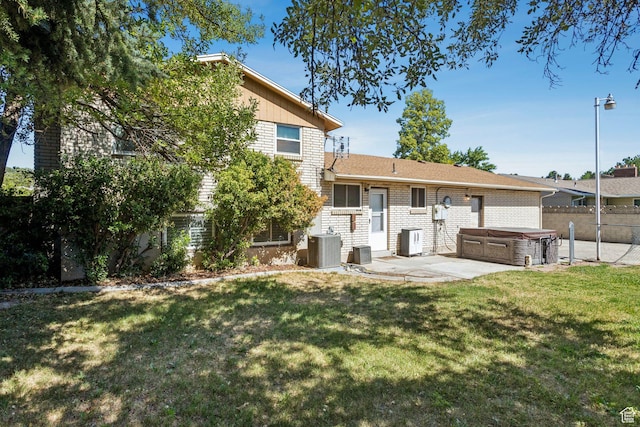 6924 S 2160 W, West Jordan, UT 84084 - back of property with a hot tub, a patio, and brick siding