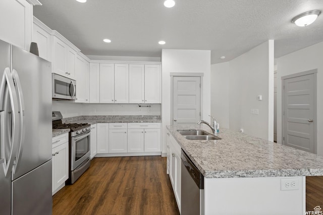 5958 W 8100 S, West Jordan, UT 84081 - kitchen with appliances with stainless steel finishes, dark wood-style flooring, an island with sink, white cabinets, and recessed lighting