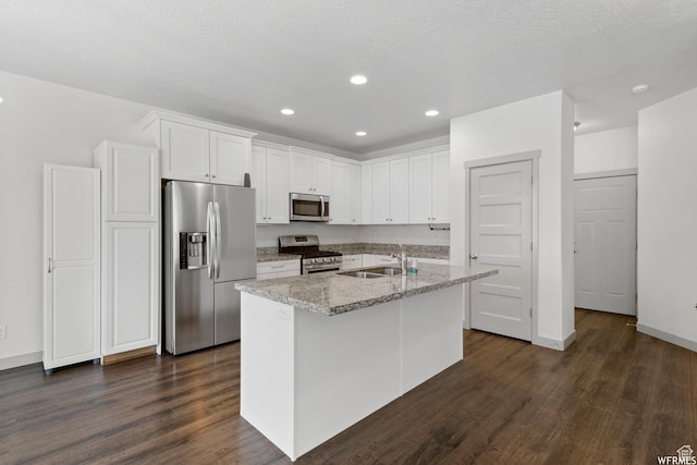 5958 W 8100 S, West Jordan, UT 84081 - kitchen featuring stainless steel appliances, dark wood-type flooring, white cabinetry, an island with sink, and recessed lighting