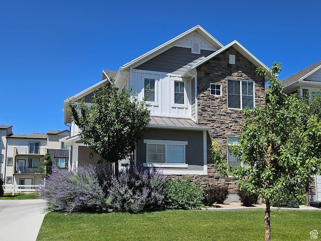 5958 W 8100 S, West Jordan, UT 84081 - craftsman inspired home featuring stone siding, a standing seam roof, a front lawn, board and batten siding, and stucco siding