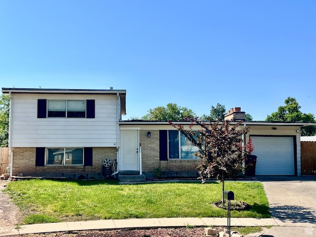 3917 S David Pl, West Valley City, UT 84119 - view of front of home featuring a garage, brick siding, concrete driveway, and a chimney