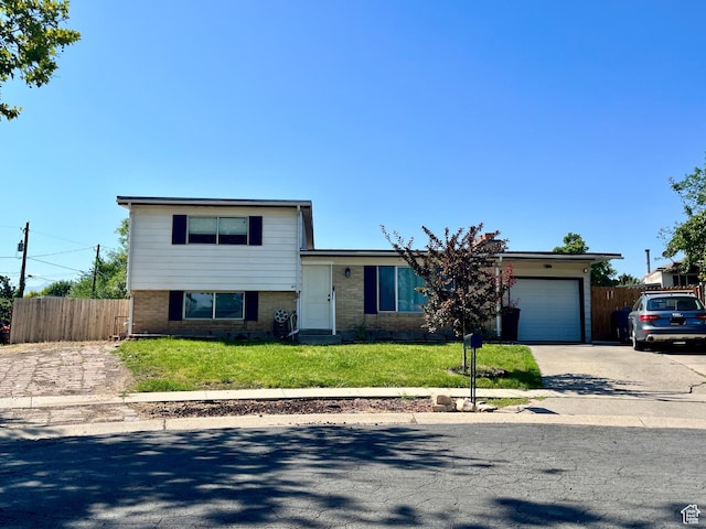 3917 S David Pl, West Valley City, UT 84119 - tri-level home with driveway, a garage, and brick siding