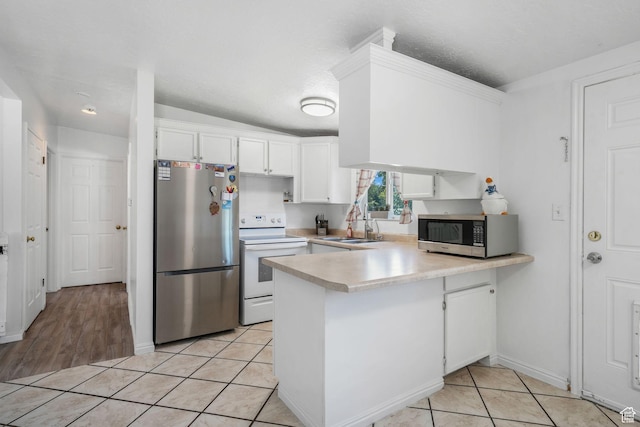 4245 S 3760 W, West Valley City, UT 84120 - kitchen featuring appliances with stainless steel finishes, a peninsula, light countertops, white cabinets, and light tile patterned floors