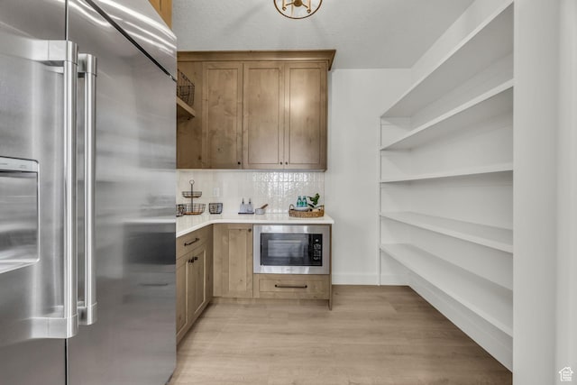 3728 W Chalgrove Rd, Taylor, UT 84401 - kitchen with appliances with stainless steel finishes, open shelves, light wood-type flooring, tasteful backsplash, and light countertops