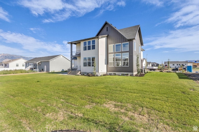 3728 W Chalgrove Rd, Taylor, UT 84401 - rear view of property with a balcony, a lawn, board and batten siding, and a residential view