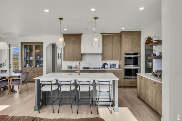 3728 W Chalgrove Rd, Taylor, UT 84401 - kitchen with stainless steel double oven, arched walkways, a breakfast bar area, light countertops, and recessed lighting