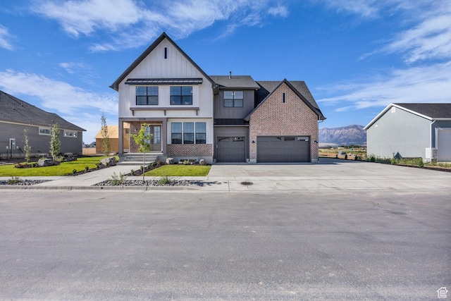 3728 W Chalgrove Rd, Taylor, UT 84401 - modern farmhouse style home featuring board and batten siding, concrete driveway, brick siding, a garage, and a mountain view