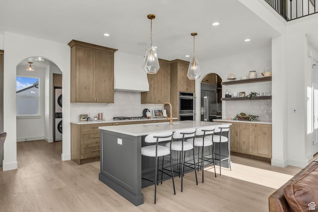 3728 W Chalgrove Rd, Taylor, UT 84401 - kitchen with stacked washer / drying machine, arched walkways, backsplash, light countertops, and recessed lighting
