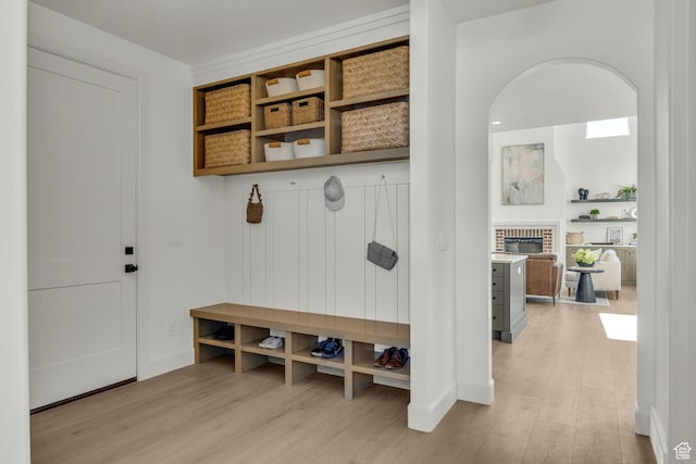 3728 W Chalgrove Rd, Taylor, UT 84401 - mudroom featuring light wood-style flooring, a brick fireplace, and arched walkways