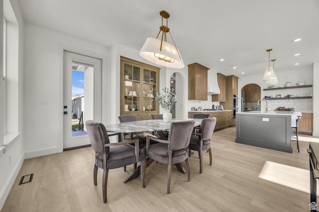 3728 W Chalgrove Rd, Taylor, UT 84401 - dining area featuring arched walkways, light wood-style floors, and recessed lighting