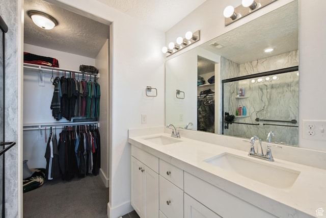 3902 W Pilton Ct, Taylorsville, UT 84129 - bathroom with a textured ceiling, double vanity, a spacious closet, and a shower stall