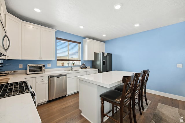 3902 W Pilton Ct, Taylorsville, UT 84129 - kitchen featuring appliances with stainless steel finishes, dark wood finished floors, white cabinets, and recessed lighting
