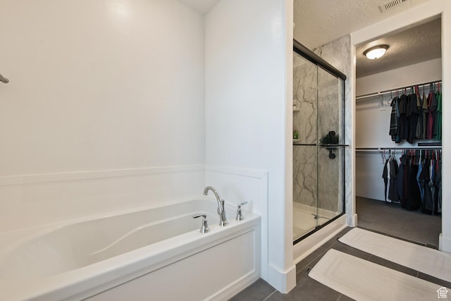 3902 W Pilton Ct, Taylorsville, UT 84129 - bathroom featuring a garden tub, a shower stall, a spacious closet, tile patterned flooring, and a textured ceiling