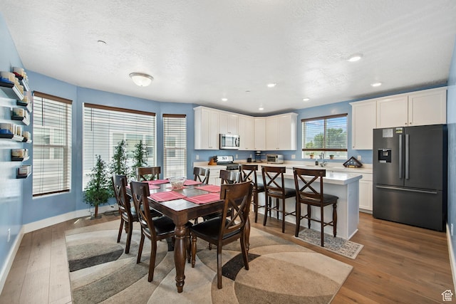 3902 W Pilton Ct, Taylorsville, UT 84129 - dining room with wood finished floors, a textured ceiling, and recessed lighting