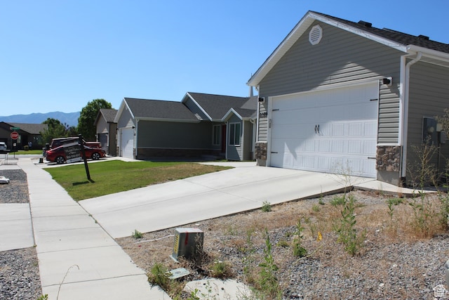 2359 E Prairie Ln, Eagle Mountain, UT 84005 - view of side of home featuring driveway, a lawn, a garage, and a mountain view