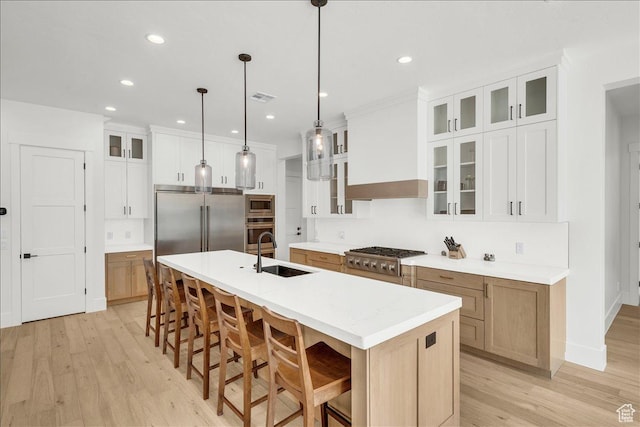 1597 W Belayer Dr, St George, UT 84770 - kitchen with built in appliances, light wood finished floors, a kitchen island with sink, light countertops, and a breakfast bar