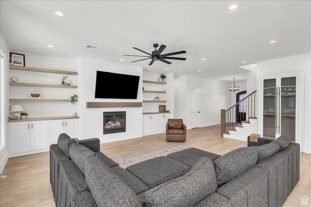 1597 W Belayer Dr, St George, UT 84770 - living room with stairway, light wood finished floors, a brick fireplace, a ceiling fan, and recessed lighting