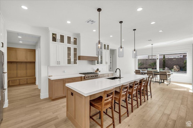 1597 W Belayer Dr, St George, UT 84770 - kitchen with light wood finished floors, a kitchen bar, backsplash, recessed lighting, and a kitchen island with sink